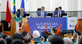 Foto mostrando a mesa de condução dos trabalhos, bem como a plateia da audiência pública realiza...