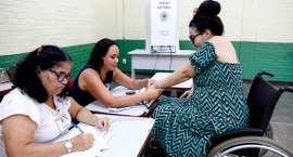 Eleitora em cadeira de rodas em seção de votação