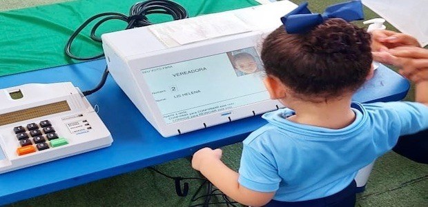 Criança pequena conhece a urna eletrônica
