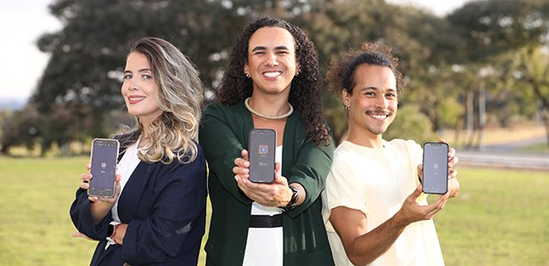 Três pessoas exibem em seus celulares o aplicativo oficial e-Título da Justiça Eleitoral