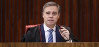 Foto de homem de pele clara, cabelos curtos, castanhos e grisalhos, sentado em uma cadeira verme...