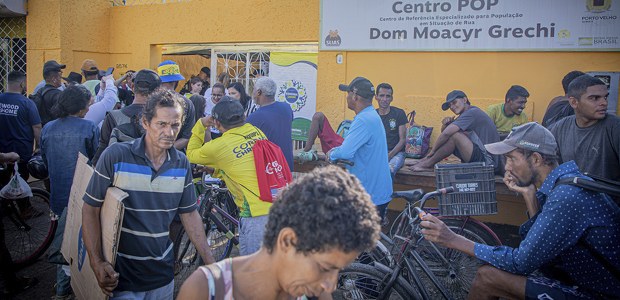 JE pelo Brasil TRE-RO - 10.09.2025 Foto colorida com várias pessoas em formação de fila em frente a um portão com grades