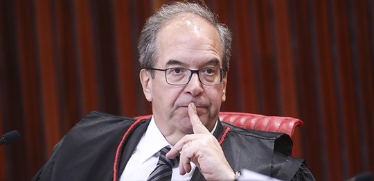 A imagem o mostra o Ministro Ricardo Villas Bôas Cueva em um ambiente formal, como um tribunal o...