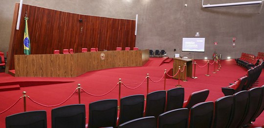 Plenario TSE. Na parte frontal, há uma bancada elevada de madeira com várias cadeiras, sugerindo...