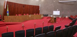 Plenario TSE. Na parte frontal, há uma bancada elevada de madeira com várias cadeiras, sugerindo...