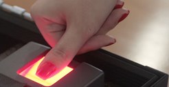 Dedo feminino no leitor biométrico.
