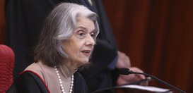 Ministra Cármen Lúcia. Ela está sentada, falando ao microfone, com expressão atenta e concentrad...