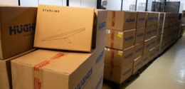 Caixas de papelão empilhadas contendo antenas de satélites.