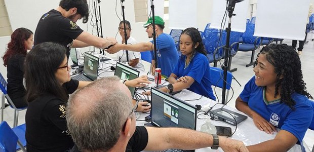 Estudantes cadastraram a biometria. Usam camisetas azuis e participam de um procedimento de tira...