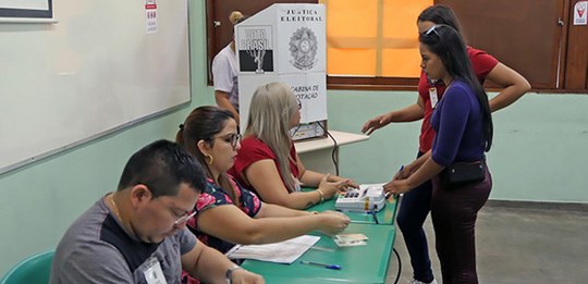Foto mostrando um dia de votação em uma seção eleitoral, com mesários e eleitores. Foto: TRE-AP