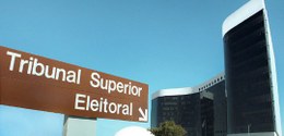 A imagem mostra uma placa de sinalização marrom com a inscrição “Tribunal Superior Eleitoral” e ...