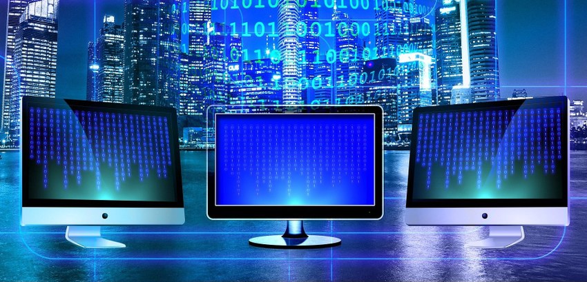 Três monitores de computador, um do lado do outro, com a tela cheia dos números o e 1 dispostos ...