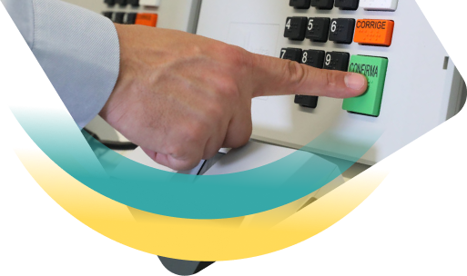 Imagem de um dedo pressionando o botão 'confirma' da urna eletrônica